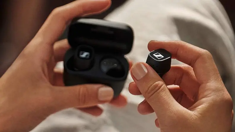 A person takes headphones out of a protective case.