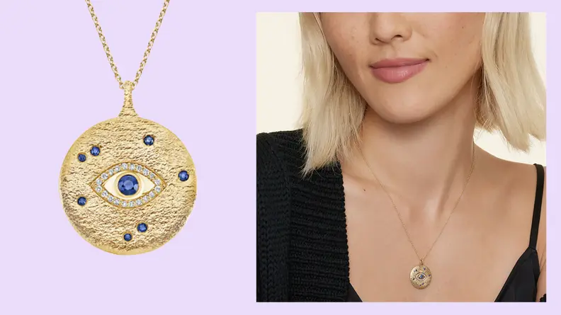 A closeup of a gold necklace with a Evil Eye sapphire and diamond medallion.