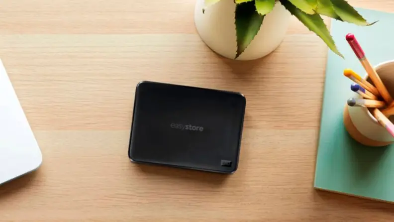 Close up of a WD portable hard drive on a desk.