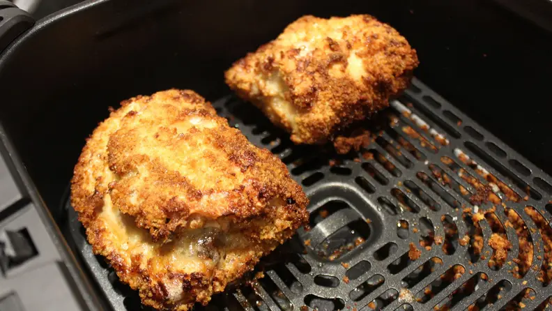 Two pieces of fried chicken in the Cosori TurboBlaze basket.