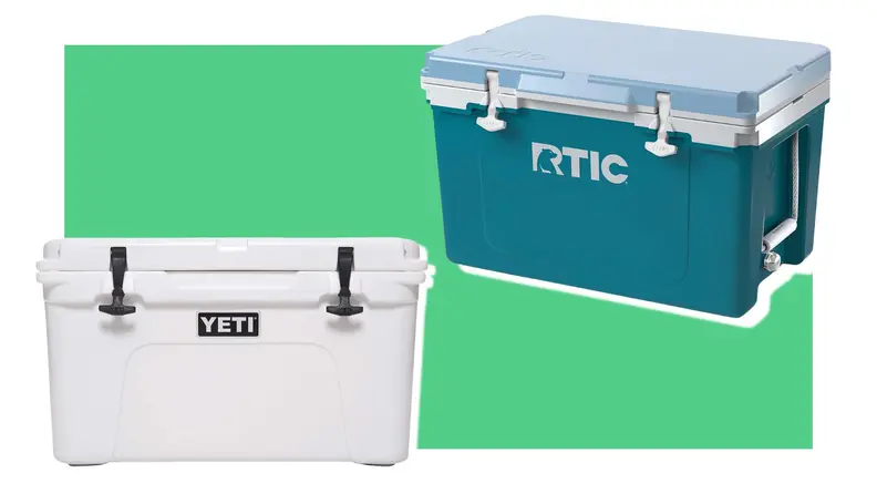 A white Yeti cooler next to a blue RTIC cooler on a green background.