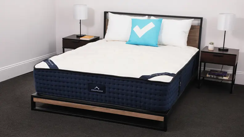 The Dreamcloud mattress in a bedroom between two bedside tables.