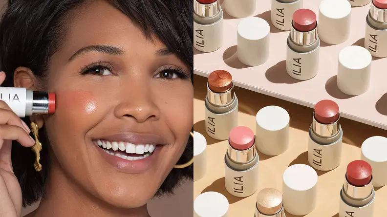 On the left: A person swatches a red blush stick onto her cheek. On the right: A tabletop covered in Ilia blush sticks in shades of pink or red.