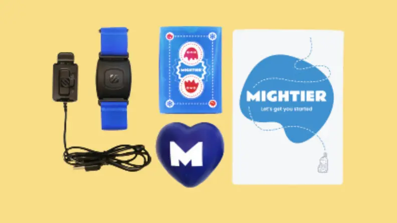 A wristband, and Mightier video game pieces laid out on a yellow background.