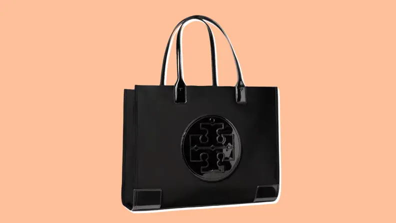 A Black Tory Burch Ella Patent Tote with a large top handle for carrying on an orange background.