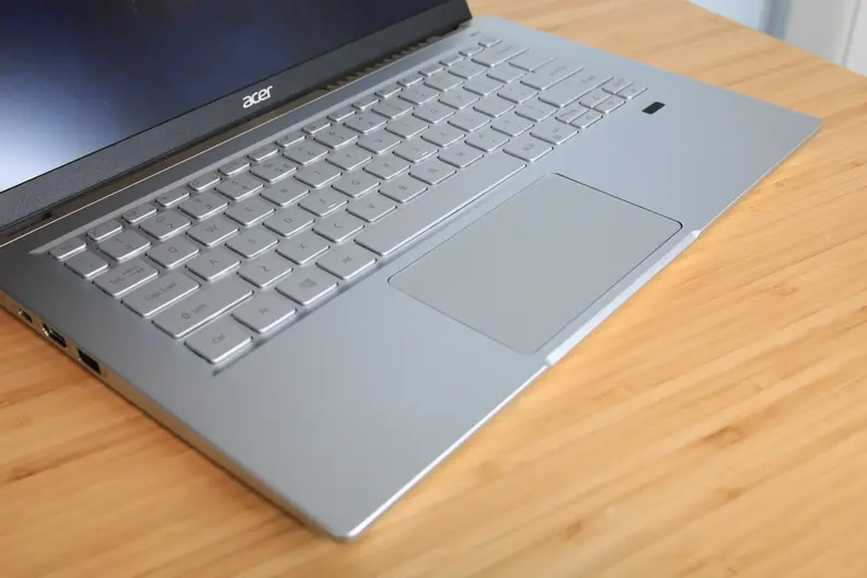 A laptop keyboard sitting on top of a light brown surface