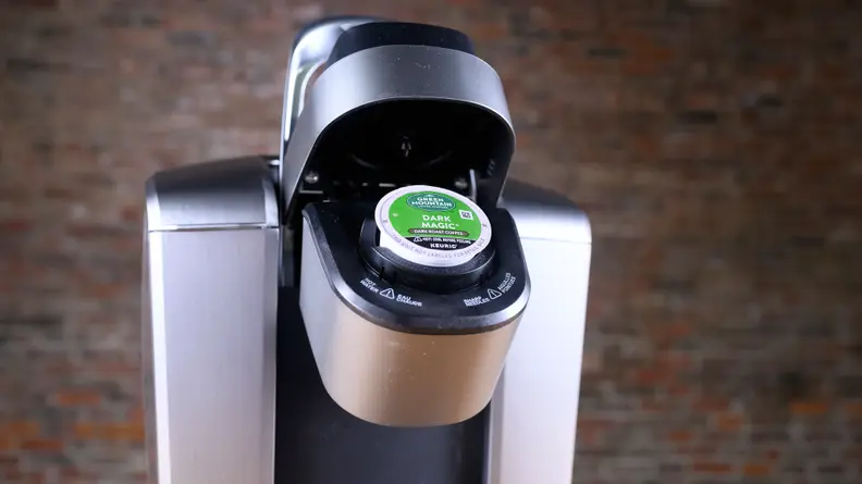 Keurig coffee maker opened, revealing a pod inserted inside