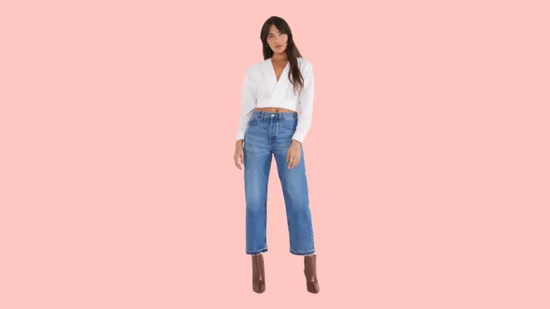 A model wearing cropped jeans and a white blouse.