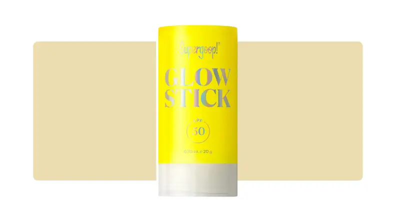 Supergoop sunscreen stick in front of a yellow background.