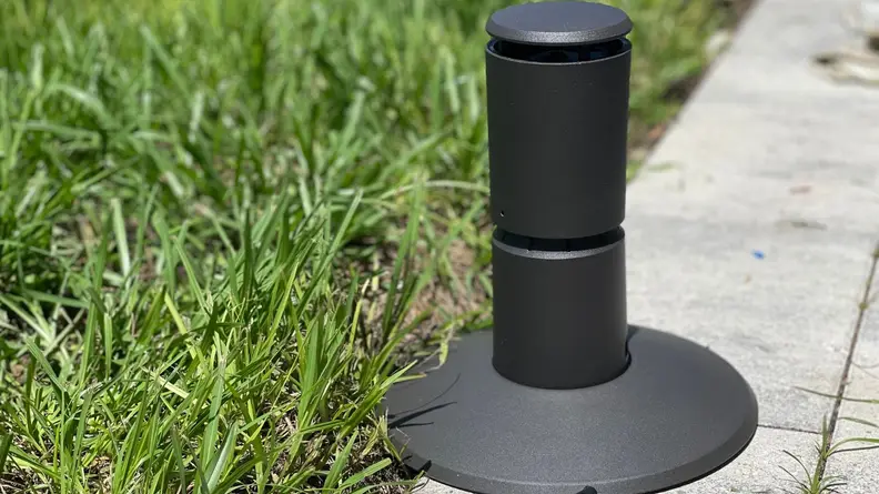 The Liv mosquito repeller next to grass on a patio