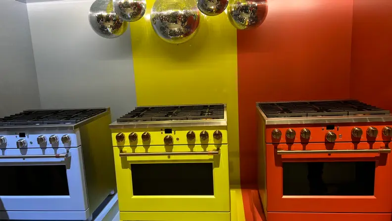 Three Cafe appliances side by side in blue, yellow, and red