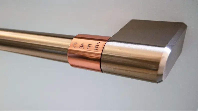 A close-up of the dishwasher's brushed copper handle, with engraved 