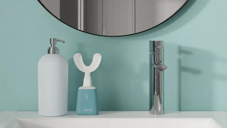 Y-Brush Essential toothbrush sits on bathroom counter next to hand soap