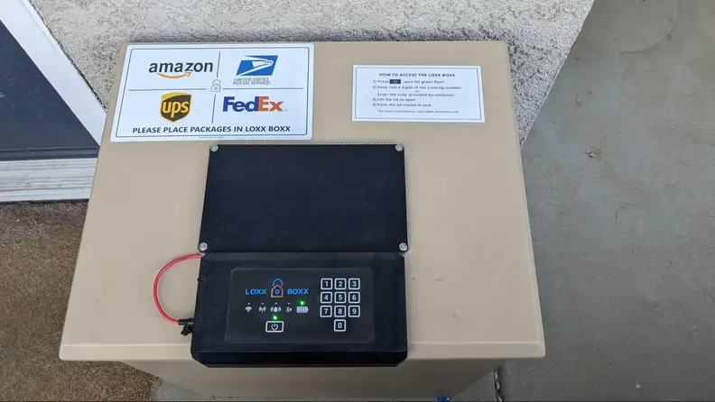 The top of the Loxx Boxx with a keypad and solar panel, and direction for placing packages inside.