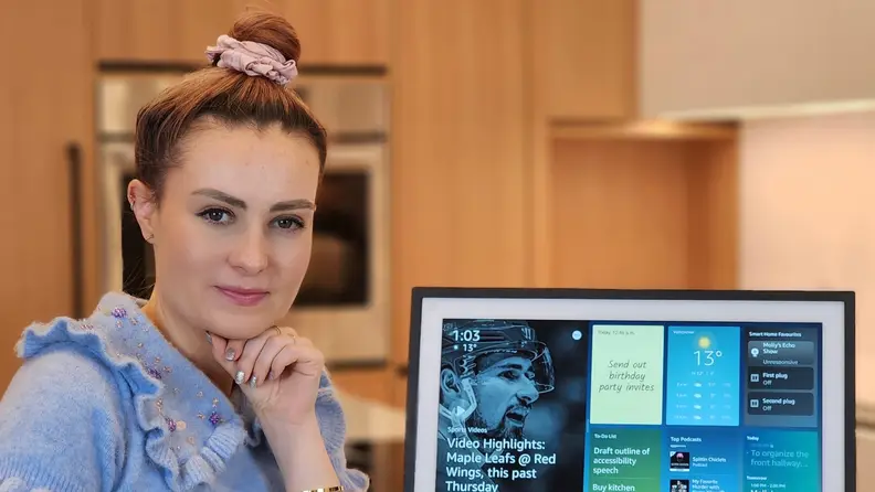 Molly Burke posing next to an Echo Show 15.