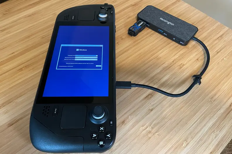 A black handheld gaming console showing part of the Windows 11 OS installation process