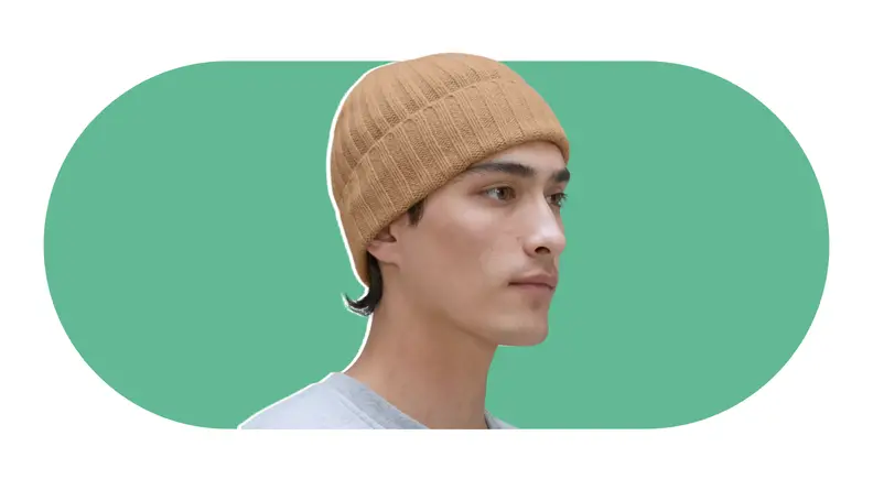 A model wearing a knit camel cashmere beanie.