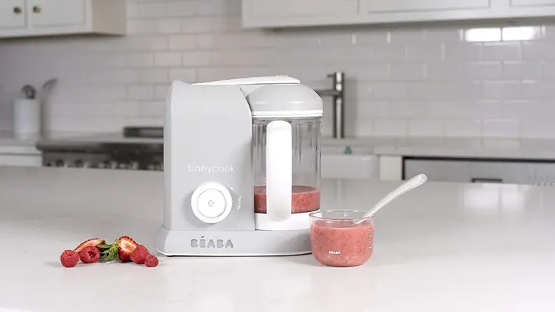 A Beaba baby food maker sits on a white counter.