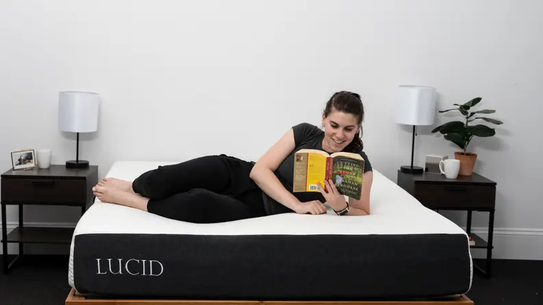 a person lies on their side on the lucid mattress