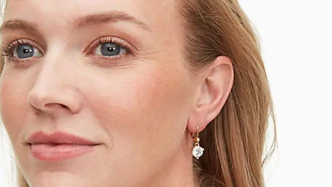 Woman smiling while wearing Kate Spade jewelry