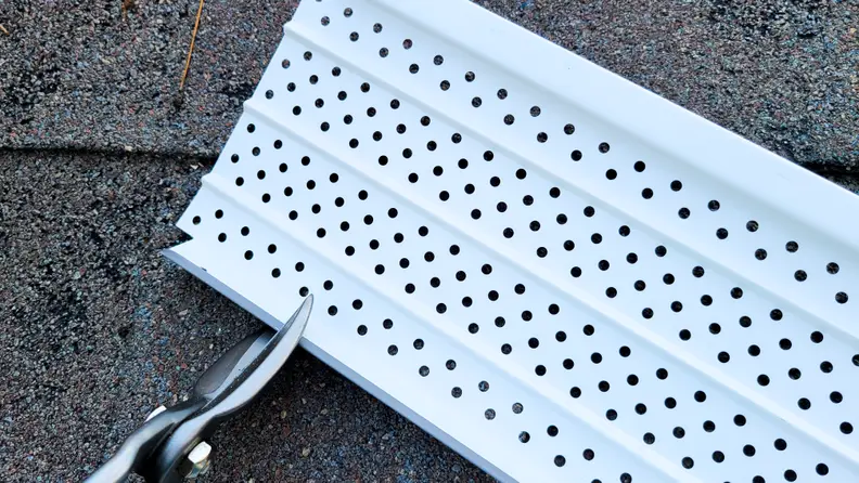 Gutter guards being cut by tin snips