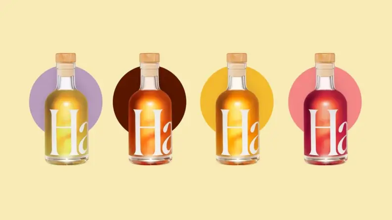 Four bottles of Haus aperitifs against a pale yellow background.