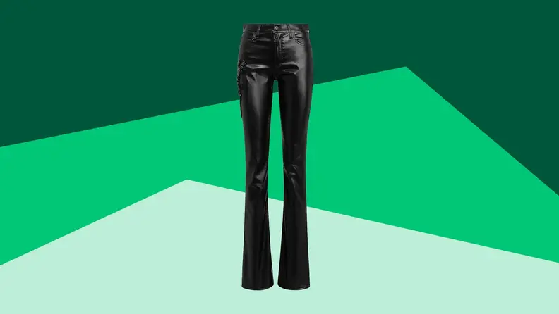 A pair of black leather trousers against a green background.
