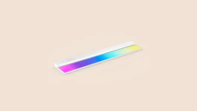 A rainbow colored strip of light appears on a beige background.