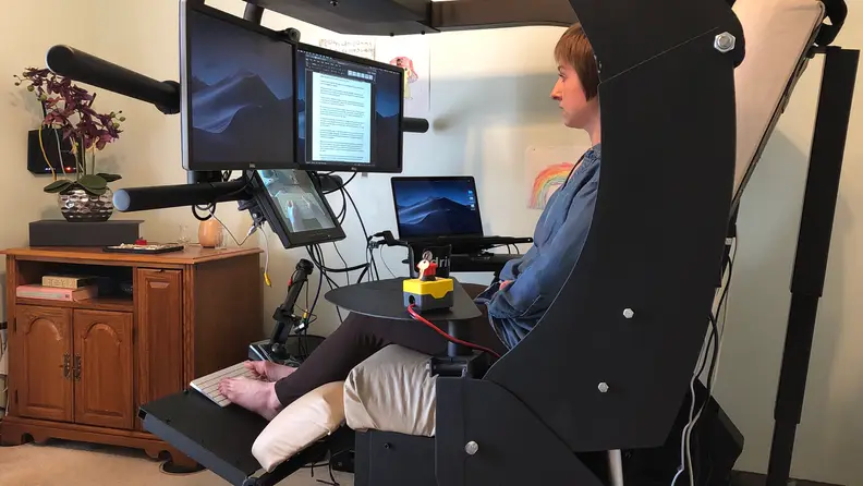 Author sitting in workstation, upright