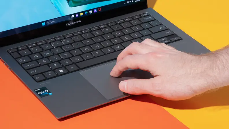 A person clicking on the mouse pad on the Asus Zenbook S 13 OLED (2023).
