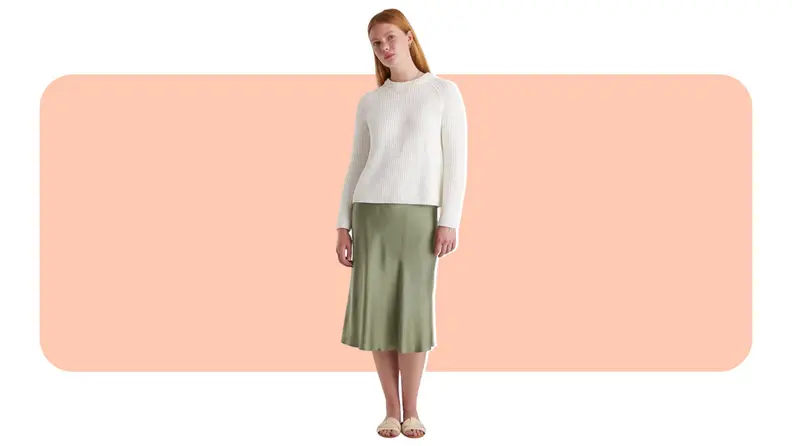 A model wearing a green silk midi skirt.