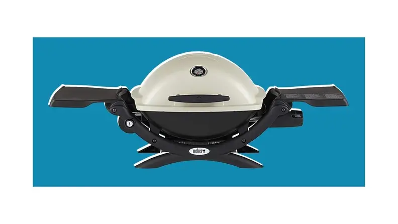 A Weber portable grill on a blue background.