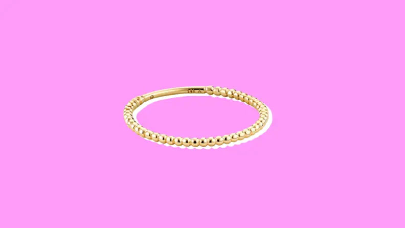 Mejuri Gold Beaded Ring on a purple background.
