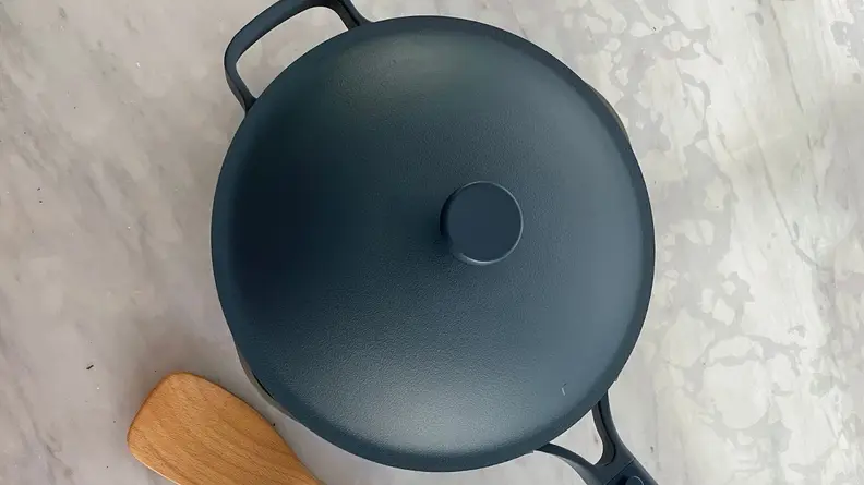 Always Pan 2.0 in Blue Salt color with lid on next to wooden spoon.