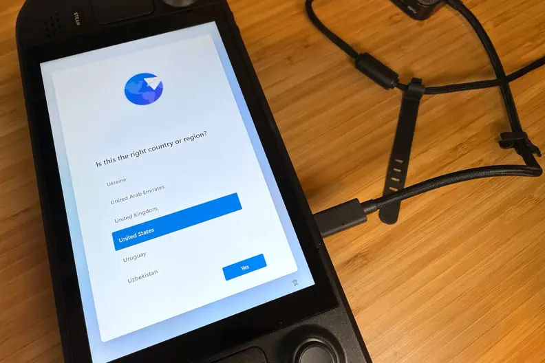 A black handheld gaming console showing part of the Windows 11 OS installation process