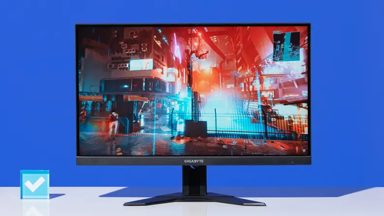 The Gigabyte M27U on a white table with a blue background.