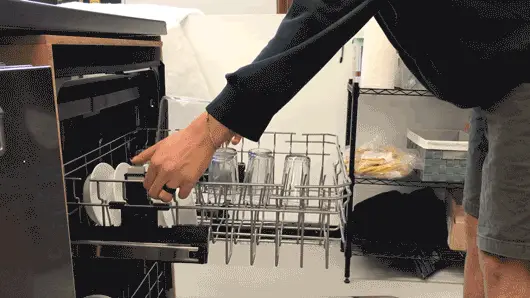 A gif showing a lab technician adjusting the dishwasher's upper rack vertically.