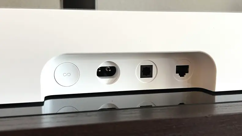The input section for the white Ray soundbar is shown on a black and brown console.