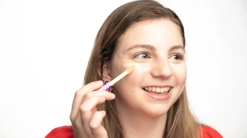 The author applying the Tarte Shape Tape Concealer under her eyes.