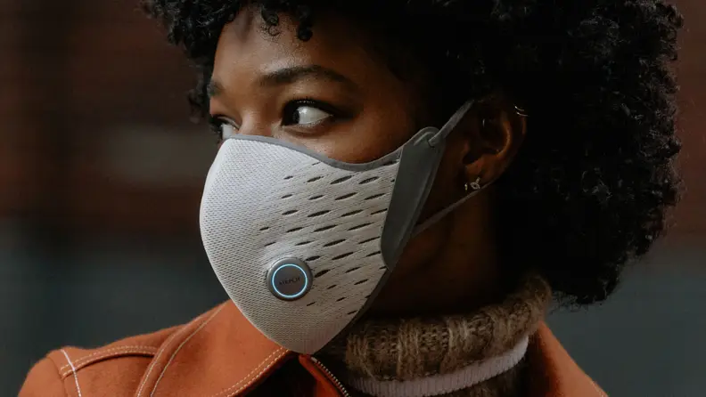 Close-up: A model sports the AirPop Active-Plus face mask, which is white and gray and features a purifier and smart sensor.