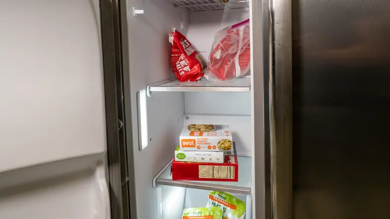 A close-up of the Frigidaire Gallery GRSC2352AF side-by-side refrigerator's freezer compartment, with some food