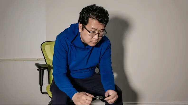 Man sitting in a chair wearing blue Go-to Hoodie from Public Rec