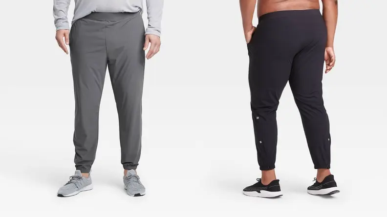 A pair of models pose in two styles of jogging pants (one gray and one black).