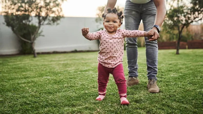 Shot of an adorable baby girl having fun with her dad in their backyard