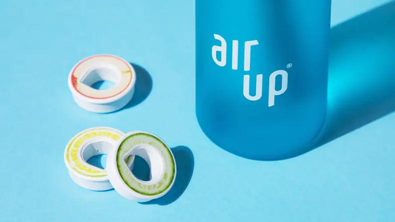 Three flavor pods next to a blue Air Up bottle