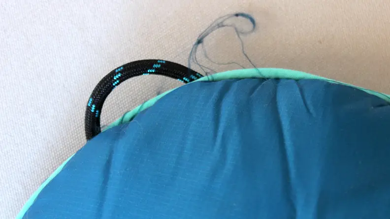 Frayed ends of navy blue insulated blanket.