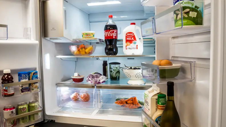 A shot of the interior of the Frigidaire FG4H2272UF refrigerator, showcasing the storage inside of the doors and on the main cavity's shelving. Everything is fully stocked with groceries.