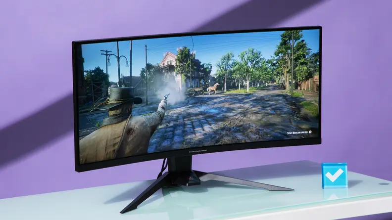 A cowboy shoots a gun in the direction of a horse-led wagon on the screen of an ASRock Phantom Gaming PG34WQ15R2B monitor.