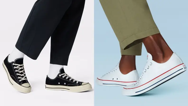 Person wearing black low top Chuck 70 sneakers, person wearing Chuck Taylor All Star low tops in white.