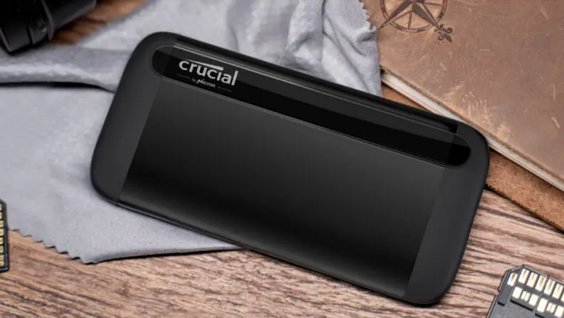 A Crucial X8 portable SSD sits on a table.